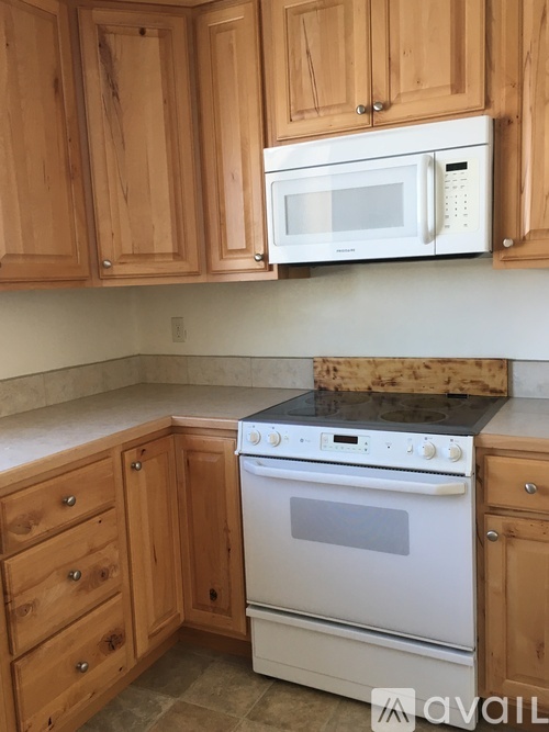 A kitchen with wooden cabinets and a white oven.