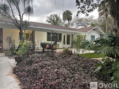 A house with a white exterior and a garden in front.