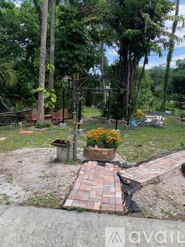 A garden with a brick pathway and a variety of plants.
