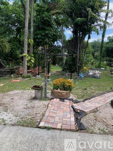 A garden with a brick pathway and a variety of plants.