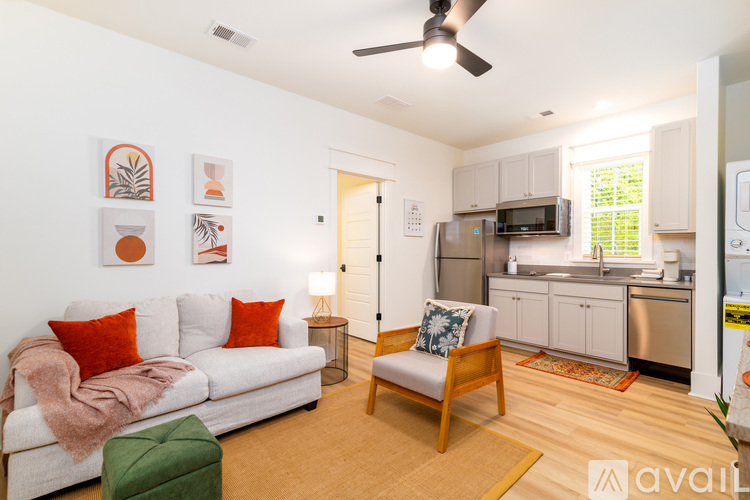 A living room with a white couch and a green ottoman.