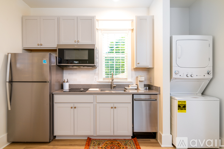 A kitchen with a refrigerator, microwave, and a dishwasher.