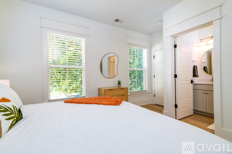 A bedroom with a large bed and a mirror on the wall.