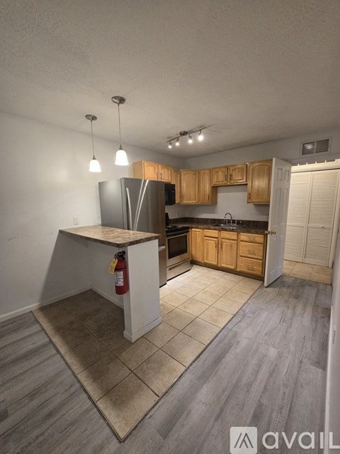 A kitchen with wooden cabinets and a white island.