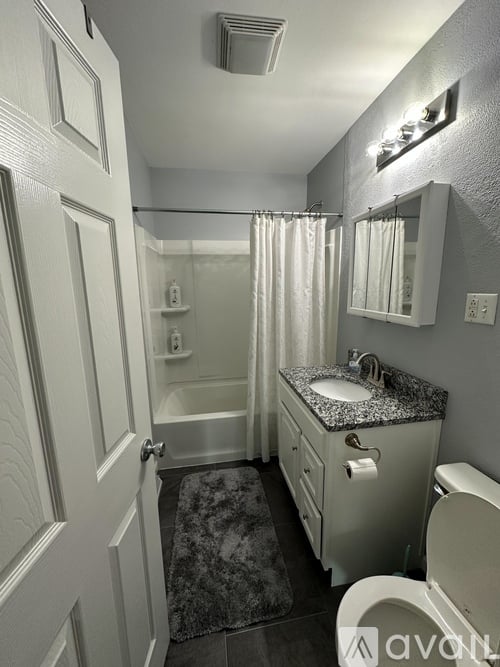 A bathroom with a toilet, sink, and shower.