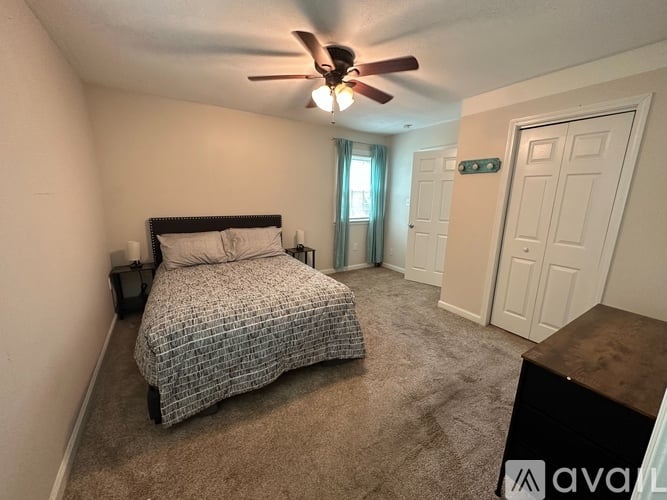 A bedroom with a bed, dresser, and window.