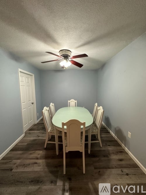 A dining room with a table and chairs.