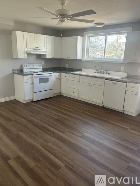A kitchen with white appliances and cabinets.