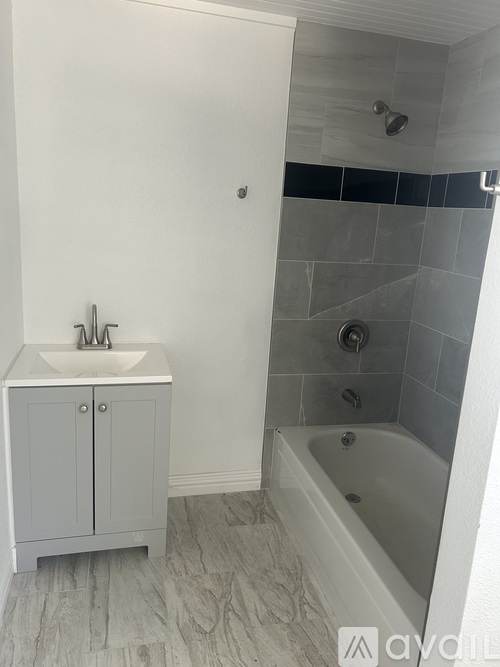 A white bathroom with a white sink and a white bathtub.