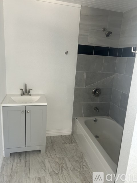 A white bathroom with a white sink and a white bathtub.