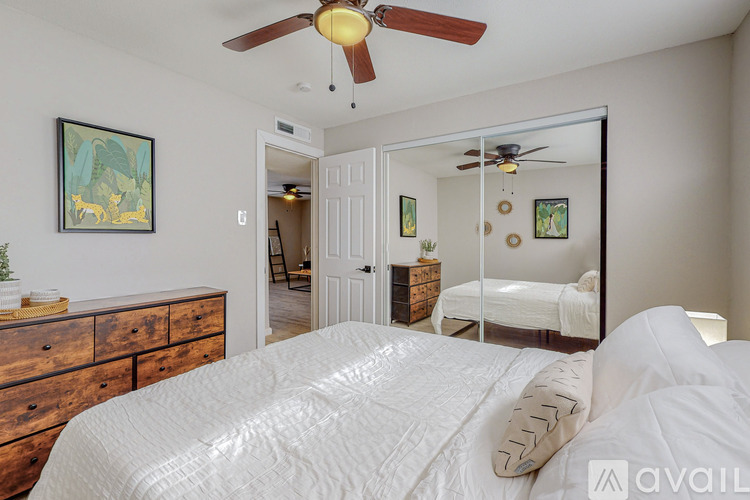 A bedroom with a large bed and a ceiling fan.