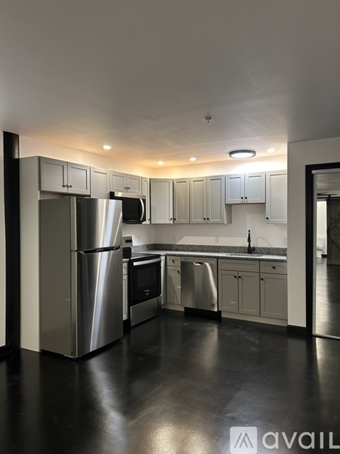 A modern kitchen with stainless steel appliances and white cabinets.