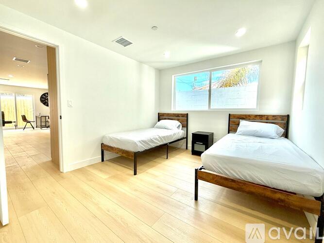 A bedroom with two beds and a wooden floor.