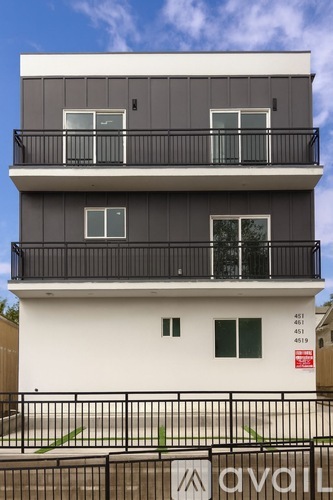 A modern two-story building with balconies and windows.