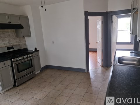 A kitchen with a black countertop and a stove top oven.