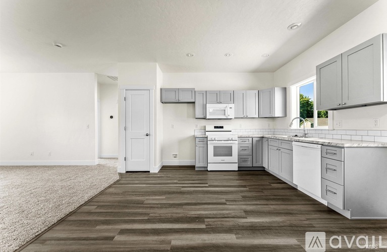 A kitchen with white appliances and cabinets is available for rent.
