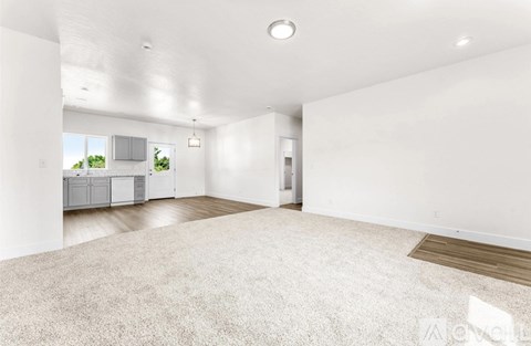 A large empty room with a carpeted floor and white walls.