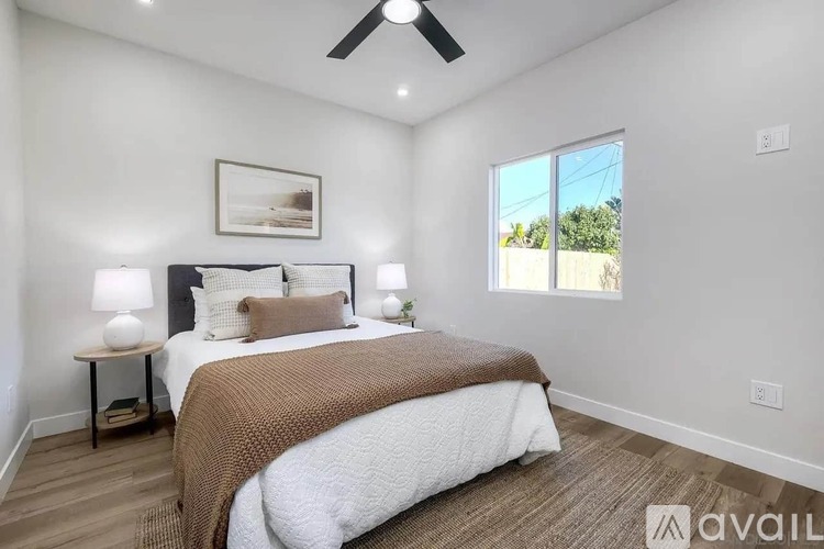 A bedroom with a large bed and a ceiling fan.
