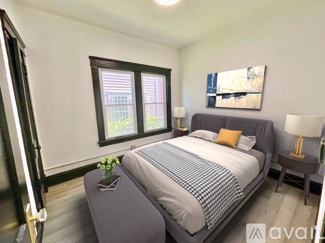 A bedroom with a bed, nightstands, and a window.