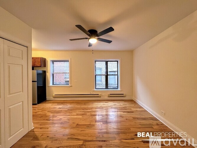 A spacious room with a ceiling fan and wooden flooring.