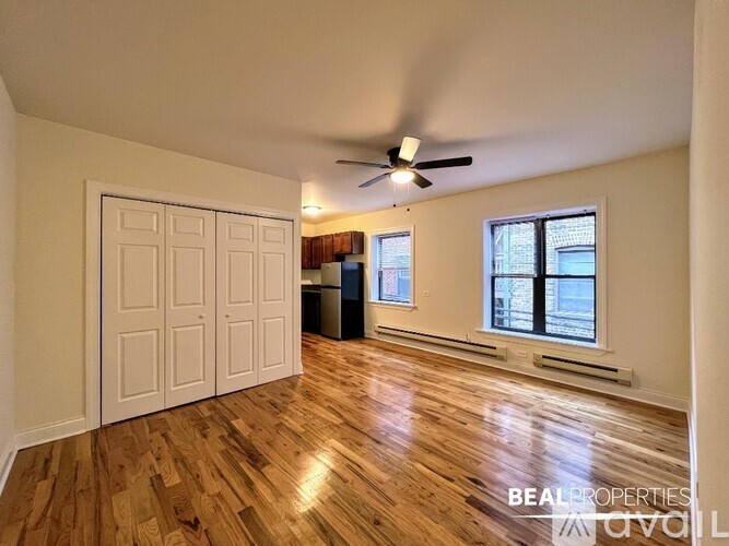 A room with a ceiling fan and wooden flooring.