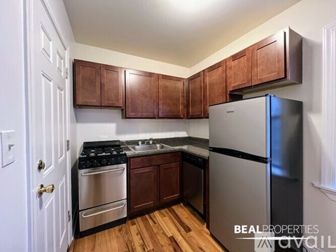 A kitchen with wooden cabinets and a stainless steel refrigerator.