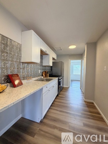 A kitchen with white cabinets and a countertop with a bowl on it.
