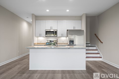 A modern kitchen with white cabinets and a central island.