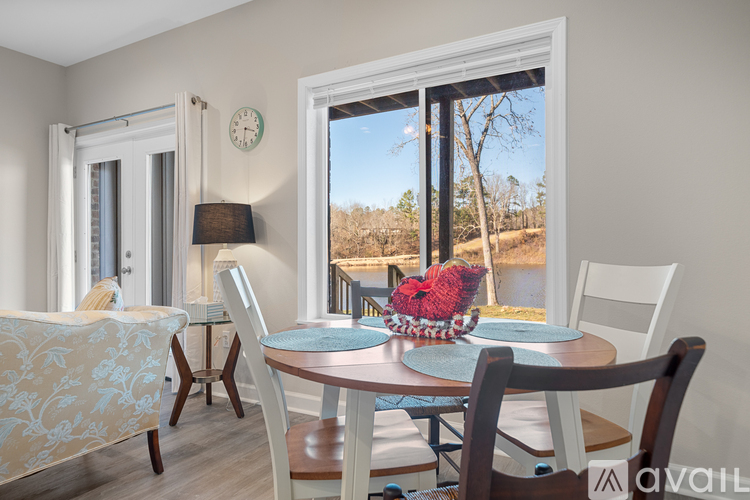 A dining room with a table set for two and a view of the outdoors through a large window.