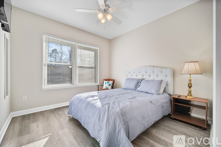A bedroom with a large bed and a ceiling fan.