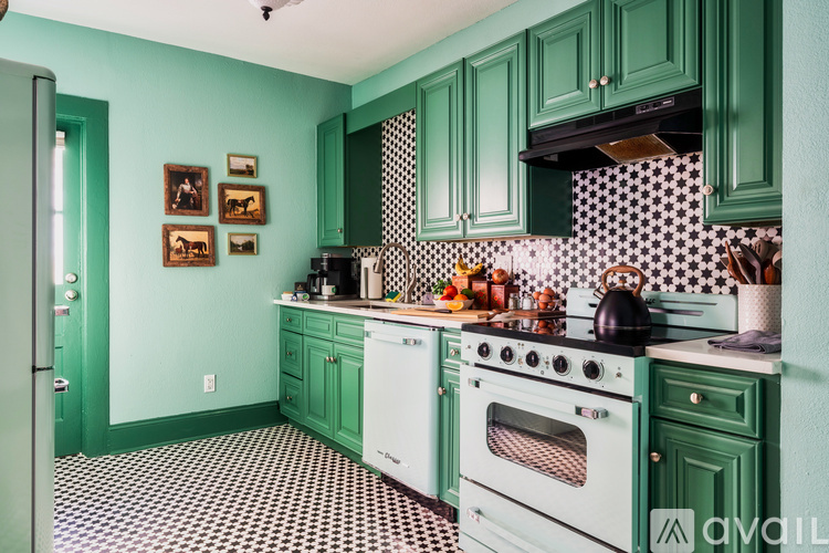 A kitchen with green cabinets and a black and white checkered floor.