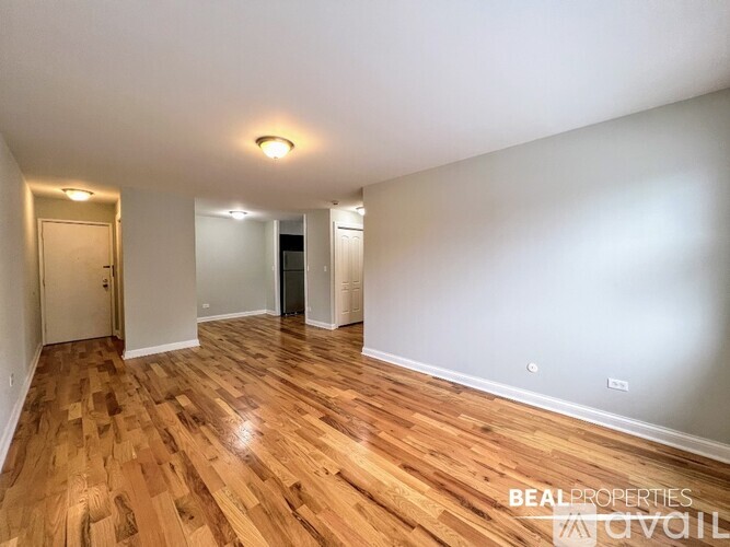 A room with wooden flooring and white walls.