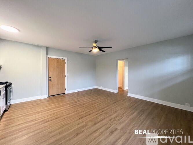 A room with wooden flooring and a ceiling fan.