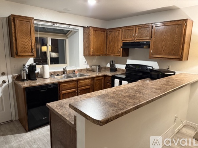 A kitchen with brown cabinets and a granite counter.