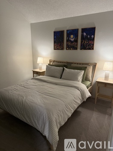 A bedroom with a large bed and two nightstands with lamps.