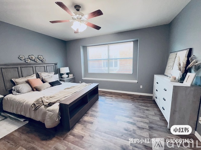 A bedroom with a bed, dresser, and window.