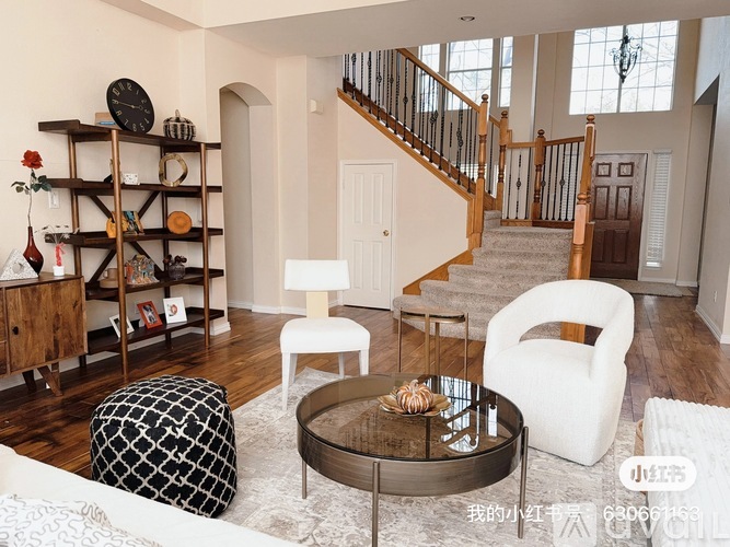 A living room with a staircase in the background.