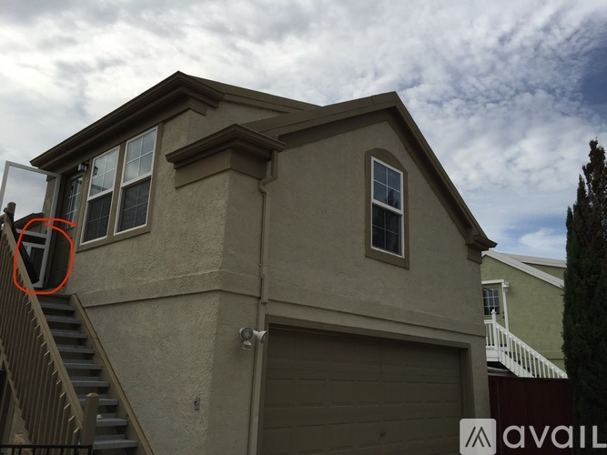 A house with a garage and a staircase leading to the entrance.