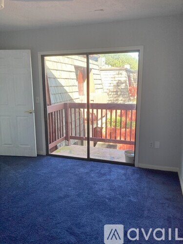 A room with a sliding glass door leading to a backyard.