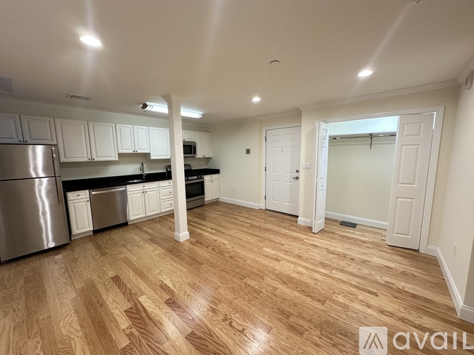 A kitchen with wooden floors and white walls.