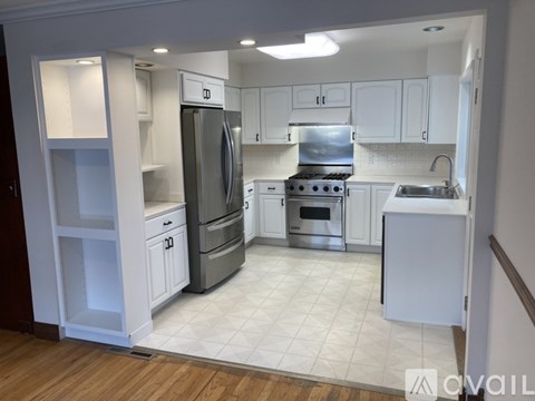 A kitchen with white cabinets and appliances.