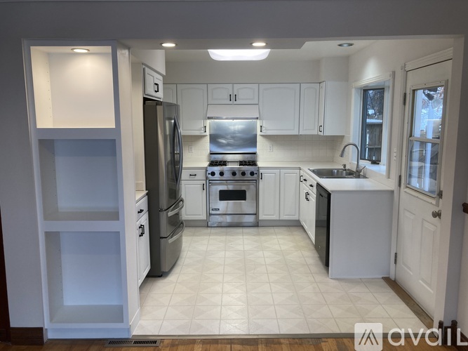 A kitchen with white cabinets and appliances.