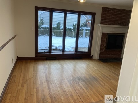 A room with wooden floors and a fireplace is available for rent.