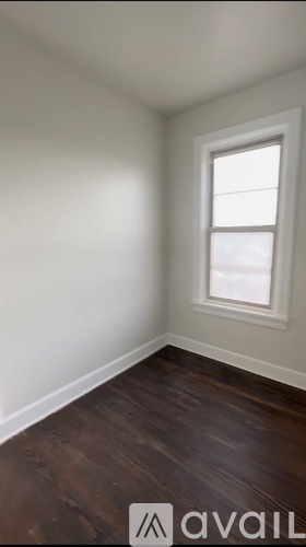 A room with a window and wooden floors.