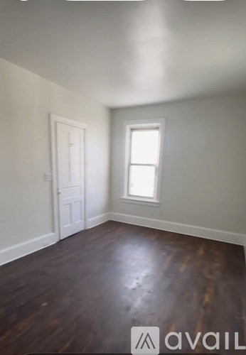 A room with a wooden floor and a window.