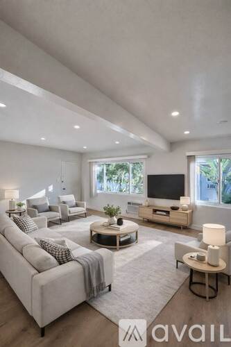 A modern living room with a large couch and a television.