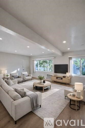 A modern living room with a large couch and a television.