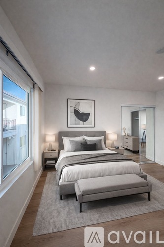 A bedroom with a large bed and a window overlooking a balcony.