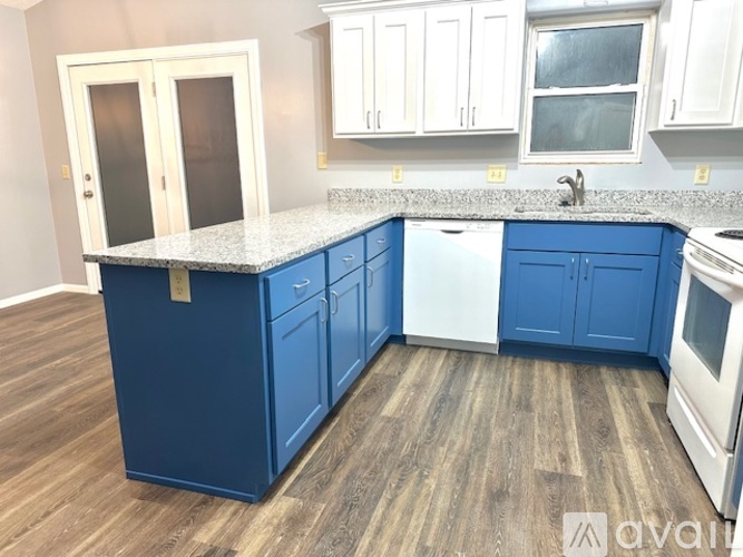 A kitchen with blue cabinets and a white fridge.