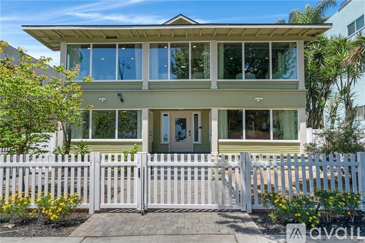 A house with a white picket fence in front.